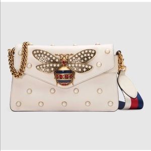 clutch all over pearl studs and metal bee detail.